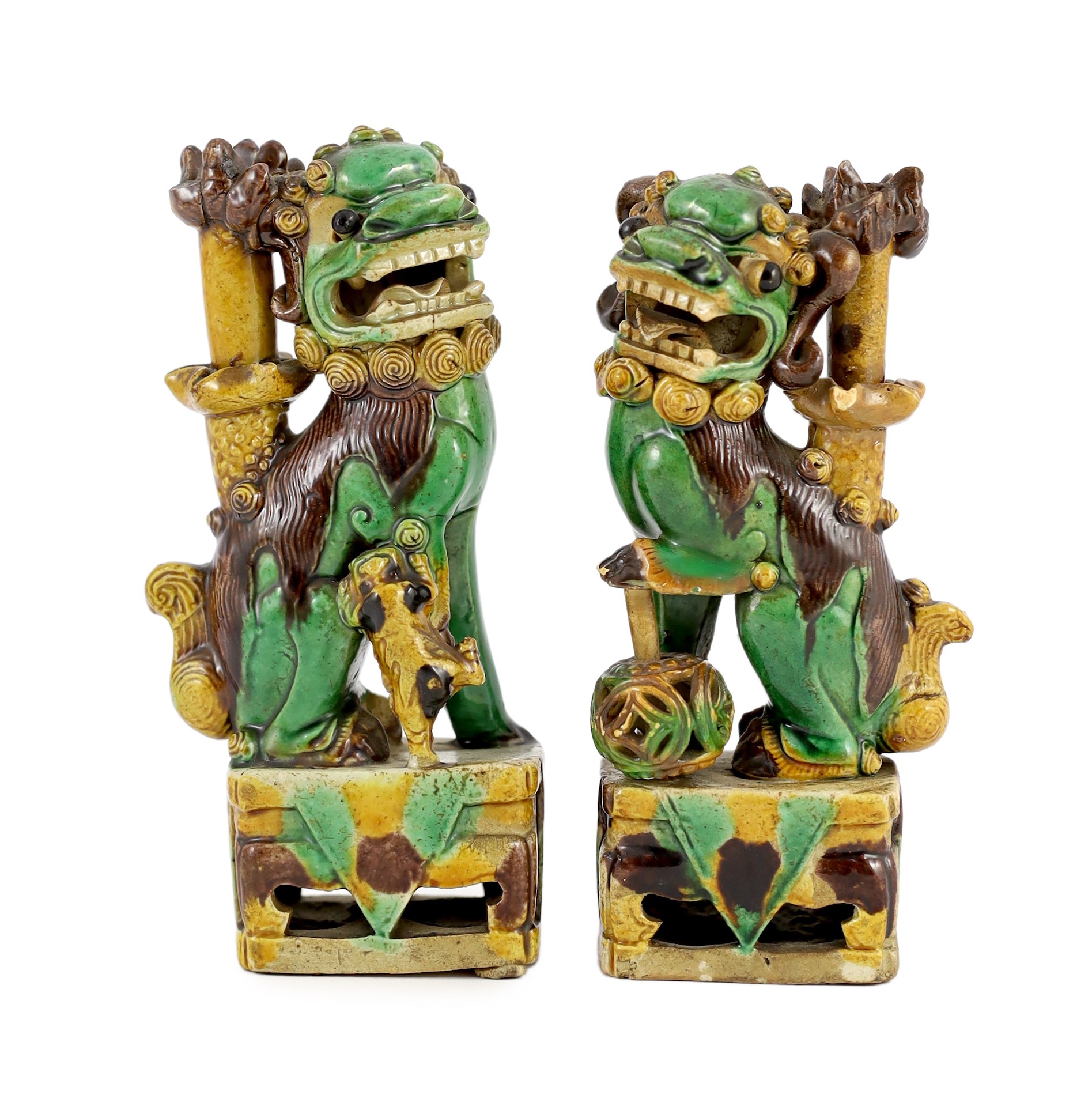 A pair of Chinese sancai-glazed biscuit Buddhist lion joss stick holders, Kangxi period, 15.5 and 16cm high, some restoration